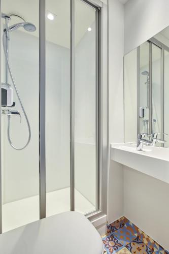 une salle de bain avec une douche, des toilettes et un lavabo dans l'établissement hotelF1 Bayonne, à Bayonne