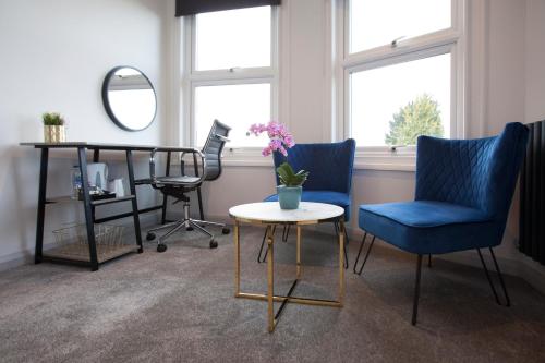 a room with two chairs and a table and a mirror at Asperion Hotel in Guildford