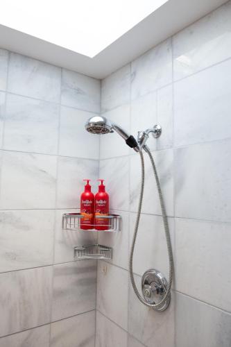 a shower with two shampoo bottles on shelves in a bathroom at Downtown Luxury Victorian Retreat in Toronto
