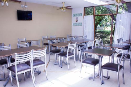 a room with tables and chairs and a tv on the wall at San Remo Viking Hotel in Pinamar