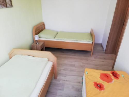 mały pokój z 2 łóżkami i 2 stołami w obiekcie Ferienwohnung, Monteurwohnung w mieście Hauswalde