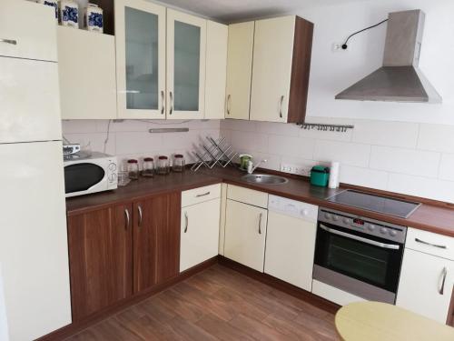 una cucina con elettrodomestici bianchi e armadietti in legno di Ferienwohnung, Monteurwohnung a Hauswalde
