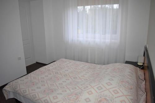 a bedroom with a bed and a window at Ośrodek Wypoczynkowy Ania Dźwirzyno in Dźwirzyno