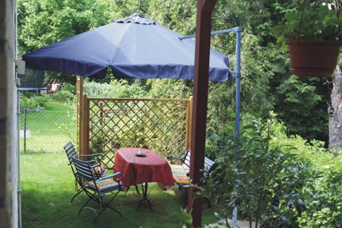 uma mesa e cadeiras sob um guarda-sol num jardim em Ferienwohnung Neumann em Berlim