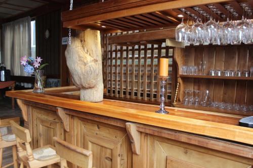 a wooden bar with chairs and wine glasses at Boye House in Futrono