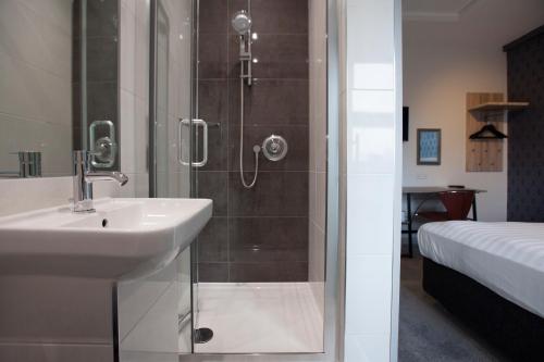 a bathroom with a sink and a shower at Asperion Hotel in Guildford