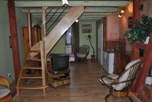 a living room with a loft bed and a television at Wilinianka in Pieszyce