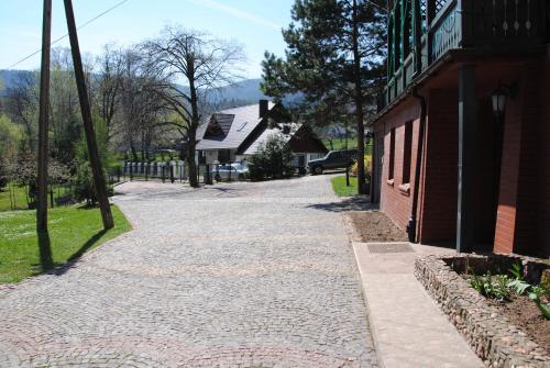 a cobblestone street next to a building and a house at Wilinianka in Pieszyce