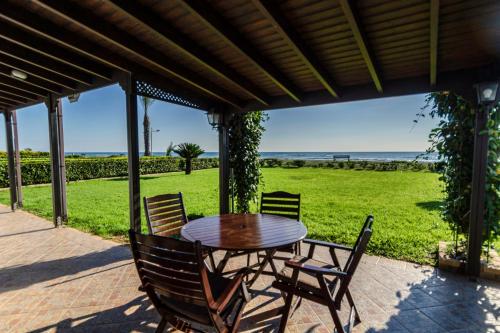 a wooden table and chairs on a patio at Blue Bay Beach House in Larnaka