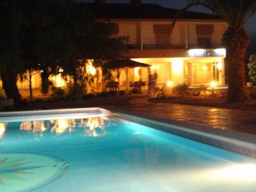 a swimming pool in front of a house at night at Hotel Plaza Miami - Sólo Adultos in Miami Platja