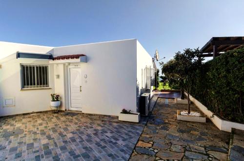 a white house with a door and a patio at Blue Bay Beach House in Larnaka
