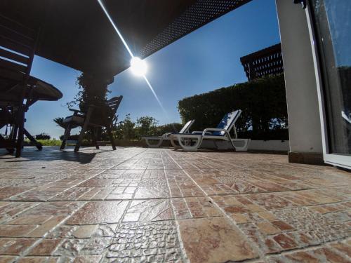 a patio with two lounge chairs on a house at Blue Bay Beach House in Larnaka