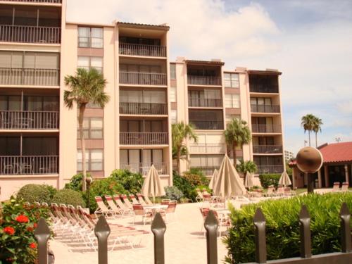un complejo con sillas y sombrillas en un patio en Siesta Breakers #603, Gulfside in Siesta Key, FL, en Siesta Key