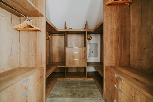 a dressing room with wooden cabinets and shelves at Exceptional 5 Star villa with breathtaking views, Sauna and fitness studio in Momjan