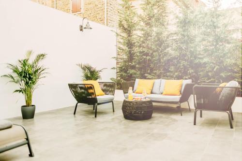 a patio with two chairs and a couch at Exceptional 5 Star villa with breathtaking views, Sauna and fitness studio in Momjan