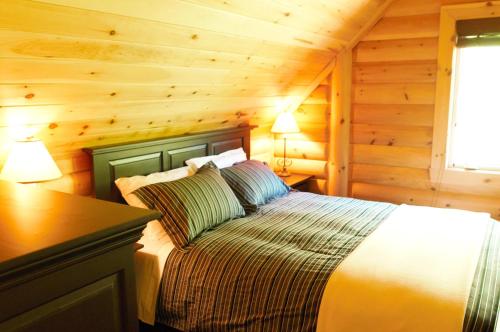 um quarto com uma cama num chalé de madeira em Selenia Lodge- Résidences et Chalets dans les Laurentides em Saint-Rémi-dʼAmherst