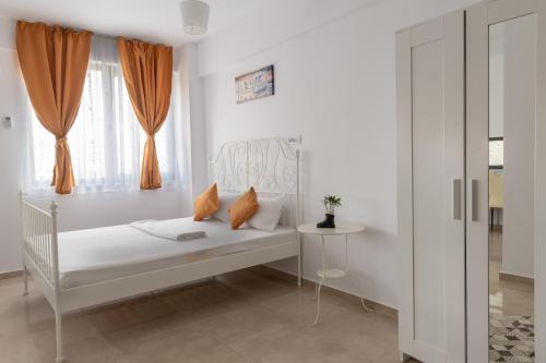 a white bedroom with a bed and a window at Studio Ambiance , Mamaia in Mamaia Nord