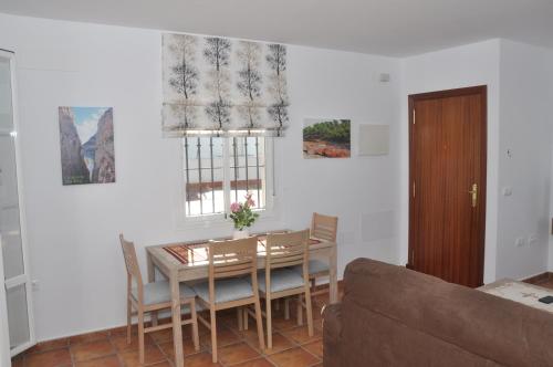 a dining room with a table and chairs and a couch at Atiko Welcome in Arcos de la Frontera
