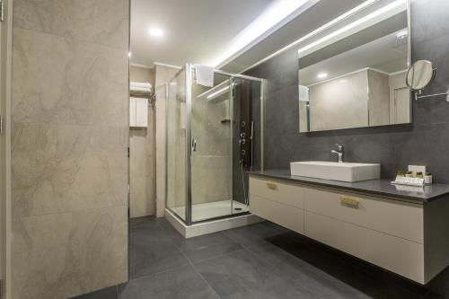 a bathroom with a sink and a shower at Willmont Hotel in Balıkesir