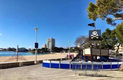 a playground in a park next to a beach at Apartamentos Las Palmeras in Palmanova