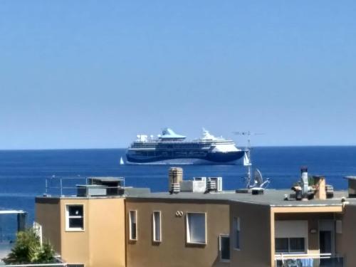 a cruise ship in the ocean behind a building at MAX and SEA parking in Sanremo