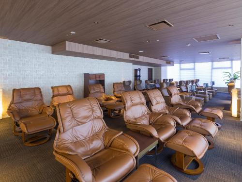 a waiting room with brown leather chairs and chairs at Himeji Castle Grandvrio Hotel in Himeji