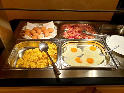 a breakfast tray with eggs and other food on a counter at Hotel Landhaus Höpen in Schneverdingen