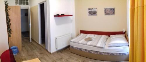 a small bed in a small room with a mirror at Apartmány Brno in Brno