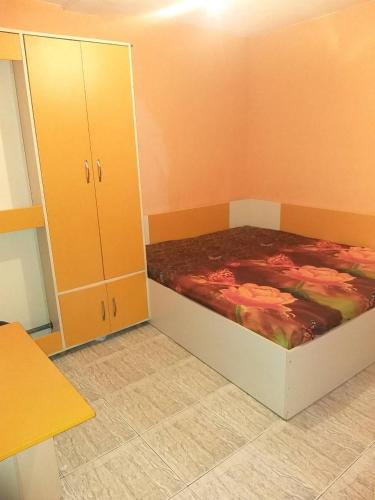 a bedroom with a bed and a cabinet at APART-JULY in Varna City