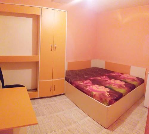 a small room with a bed and a cabinet at APART-JULY in Varna City