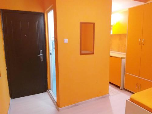 a room with a black door and a yellow wall at APART-JULY in Varna City