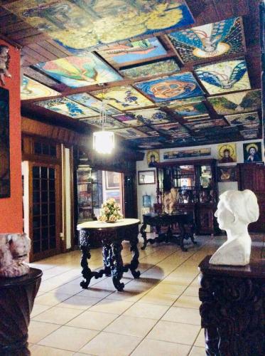 a room with a painted ceiling with a table in it at La Posada del Arcangel in Managua