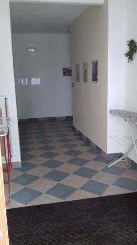 an empty hallway with a checkered floor in a building at Apartmány Brno in Brno