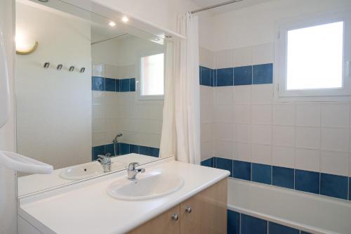 a bathroom with a sink and a mirror and a tub at Vacancéole - Port Minervois, Les Hauts du Lac in Homps