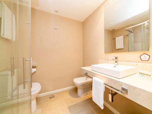 a bathroom with a sink and a toilet and a shower at Hotel Altora in Tomelloso
