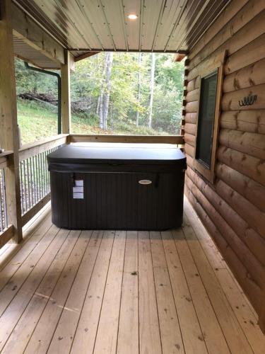 a jacuzzi tub sitting on a wooden deck at Pine Creek Cabins & Camping Resort in South Bloomingville
