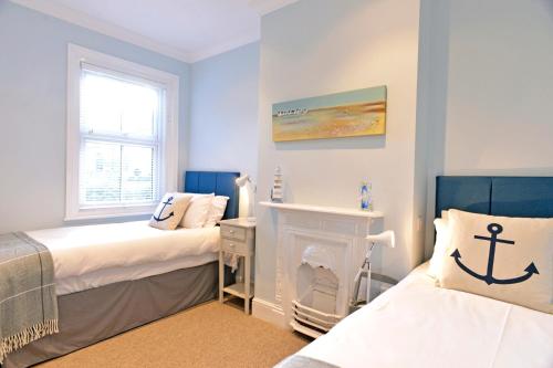 a blue bedroom with two beds and a fireplace at St Mary's Cottage in Eastbourne