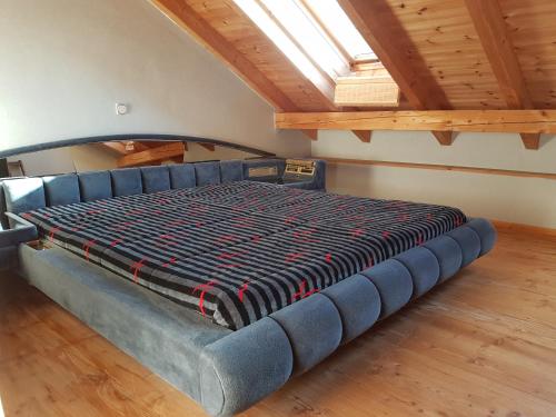 ein großes Bett in einem Zimmer mit einer Decke in der Unterkunft Ferienhaus Am Kauersberg in Fellen