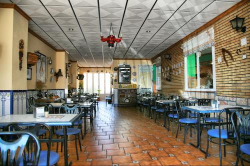 une salle à manger avec des tables et des chaises dans un restaurant dans l'établissement HOSTAL RESTAURANTE MILAN II, à San Clemente