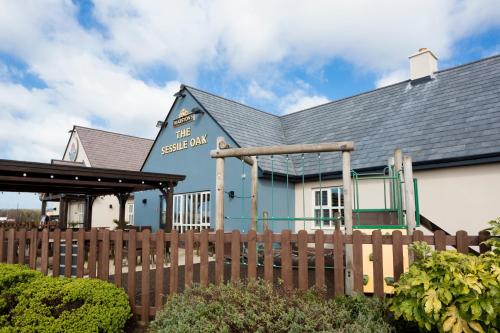 a blue and white building with a wooden fence at Sessile Oak, Llanelli by Marston's Inns in Llanelli