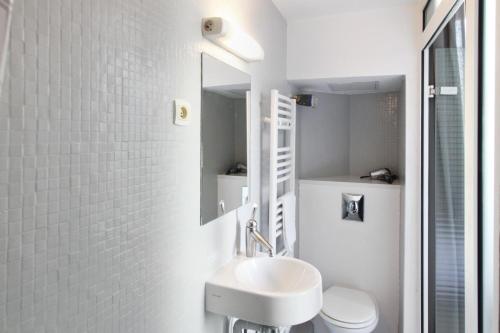 a bathroom with a sink and a toilet and a mirror at Comédie Lonjon in Montpellier