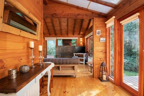 Cabaña de madera con sala de estar con sofá y TV en BOG Sulla Montagna en Villa La Angostura