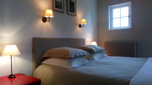 Montaure的住宿－Chambre d'hotes de la Vallee，一间卧室配有一张带两盏灯的床和一扇窗户。