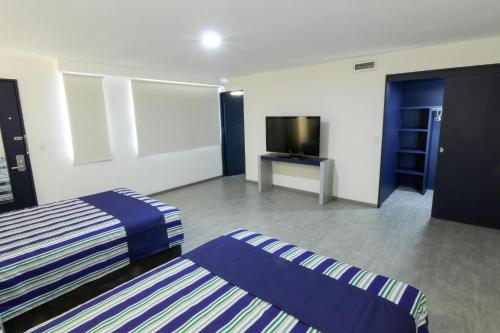 pokój hotelowy z dwoma łóżkami i telewizorem z płaskim ekranem w obiekcie Mallorca Hotel  w mieście Meksyk