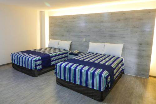 dwa łóżka ustawione obok siebie w pokoju w obiekcie Mallorca Hotel  w mieście Meksyk