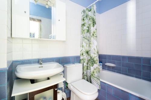 y baño con aseo, lavabo y espejo. en Home2Book El Médano Cozy Beach & Wifi en El Médano