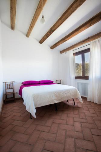 a bedroom with a large bed in a room with a window at Case Vacanze S'Arrexina in Rudalza