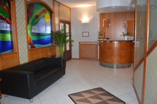 a lobby with a black couch and a stained glass window at Hotel Gilda in Laigueglia