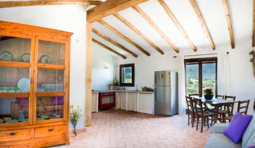 a kitchen and dining room with a table and a refrigerator at Case Vacanze S'Arrexina in Rudalza