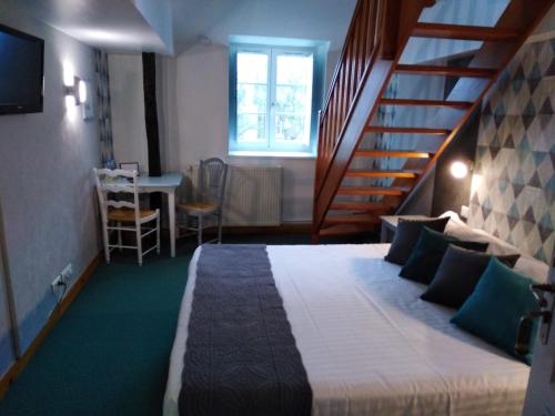 a bedroom with a bed with a staircase and a table at Hôtel Picardia in Saint-Valery-sur-Somme